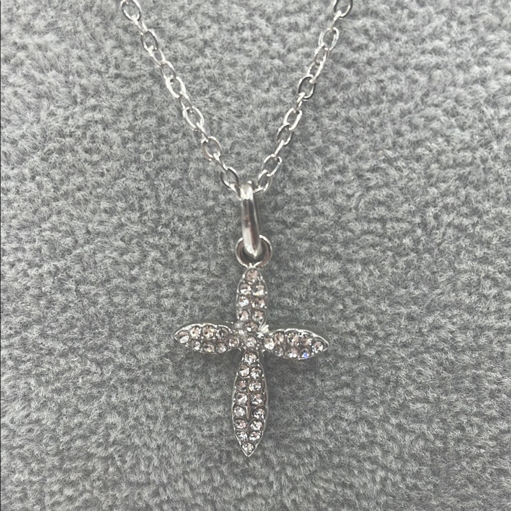 Cross Necklace in Silver Tone adorned with Rhinestones on a delicate chain.